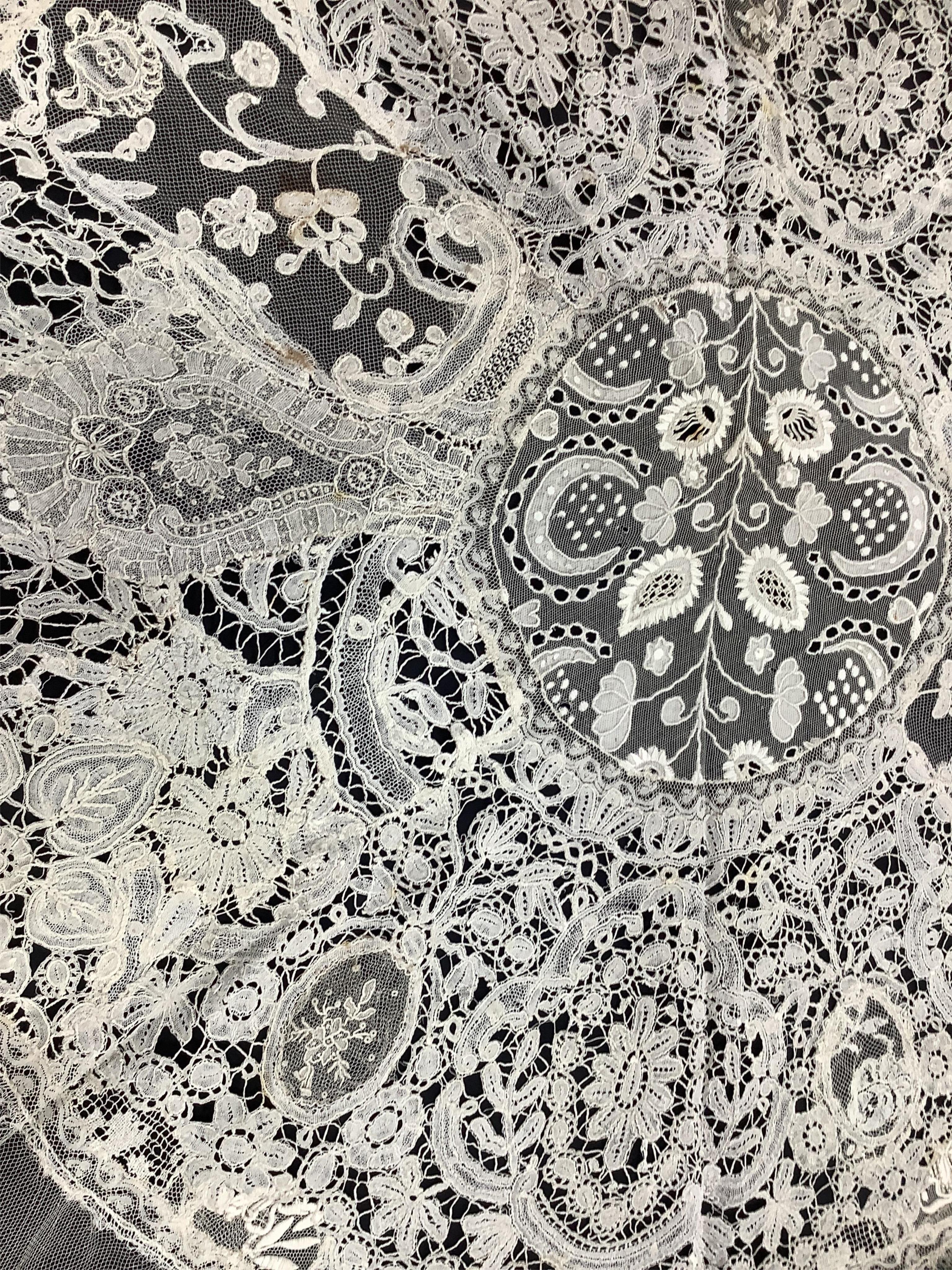A late 19th / early 20th century circular Normandy lace table cover, with five similar smaller lace mats: all patch worked together from hand bobbin and hand needle laces, possibly part of a wedding trousseau. larger clo